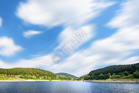 大湖蓝天下,风中,森林夏天的岸边背景