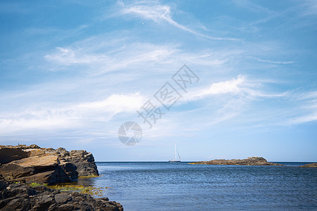 夏天,帆船蓝天下的海上,岸边悬崖图片