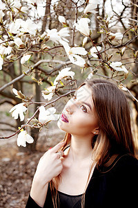 美丽的轻女人春天享受大自然的玉兰花图片