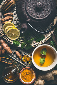 杯健康姜黄香料茶与铁茶壶配料柠檬,生姜,肉桂棒蜂蜜,顶部视图免疫促进药物,解草药图片