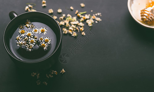 杯草药甘菊茶与干甘菊花蜂蜜黑暗的背景,顶部的视图治疗广泛的健康问题的补救措施草药治愈草药图片