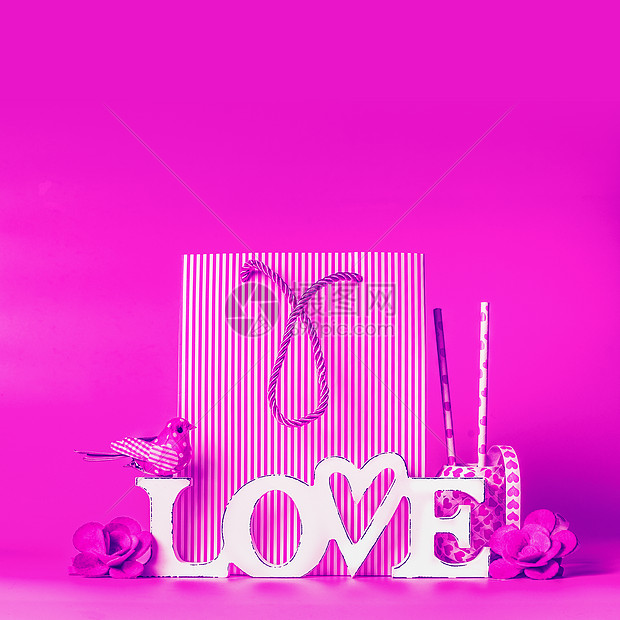 霓虹灯色彩中的创意爱情背景购物袋装饰品上写着爱的字情人节问候购物