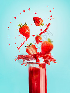 杯红色草莓飞溅夏季饮料冰沙果汁站蓝色背景与为您的,食谱文字健康饮料的图片