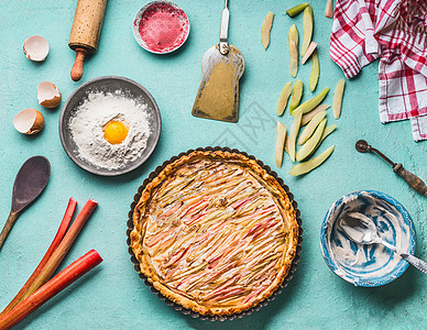 自制大黄饼,配料蓝色厨房桌子背景与烘焙用具,粉鸡蛋,顶部视图图片
