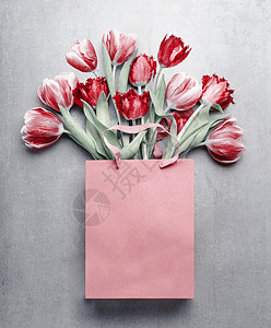 红色郁金香纸购物袋灰色背景节日的春天花花礼物作曲春季假期问候为您的图片