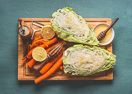 新鲜胡萝卜卷心菜沙拉的原料与油蜂蜜敷料碗厨房桌子背景,顶部视图,与素食,低热量蔬菜饮食减肥食品图片