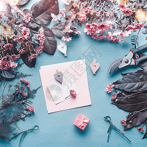蓝色花店桌子上的空白贺卡,粉红色的花心礼品盒抽象的问候母亲节,生日模拟俯视图,平躺图片