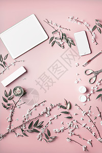 智能手机平板电脑模拟粘贴粉红色桌背景与化妆品,文具供应开花,顶部视图美容博客女商业理念平躺框架图片