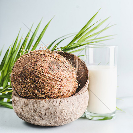 椰子牛奶桌子上的璃与整个椰子,正视图,横幅健康排营养,纯素食品清洁饮食,图片