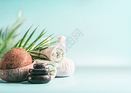 现代水疗中心椰子棕榈叶按摩设备叠按摩石,草药邮票卷毛巾健康的生活方式,美丽身体护理理念图片
