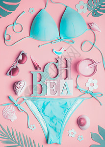 粉彩女海滩配件粉红色背景,顶部视图扁平的蓝绿色比基尼,太阳镜鸡尾酒,贝壳,热带棕榈叶文字海滩暑假图片