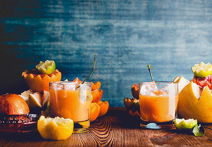 柑橘汁混合桌子上的眼镜与各种柑橘类水果成分暗墙背景维生素C饮料健康的生活方式图片