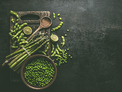 绿色芦笋与芝麻大豆,石灰青豌豆黑暗的乡村厨房桌子背景,顶部的视图健康的素食绿色烹饪配料图片