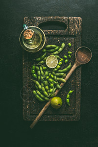 绿色芝麻大豆木制切割板上与烹饪勺子,顶部视图健康的素食图片