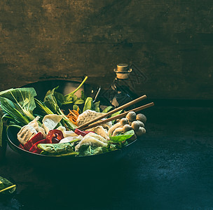 亚洲食物炒锅与五颜六色的成分为韩国素食锅深色厨房桌子上的饺子火锅准备健康的素食饮食烹饪图片