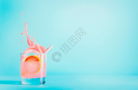 葡萄柚饮料璃与飞溅蓝色背景夏季清爽饮料粉红色柚子柠檬水图片