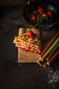 深色厨房桌子上的大黄草莓蛋糕季节糕点图片