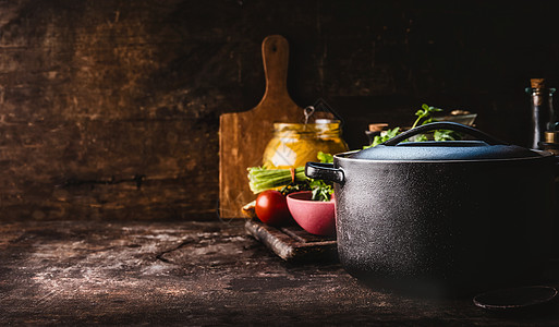 铸铁锅与新鲜草药,香料厨房用具,以美味的烹饪乡村的桌子上健康的饮食自制烹饪黑暗平静的生活食物背景图片