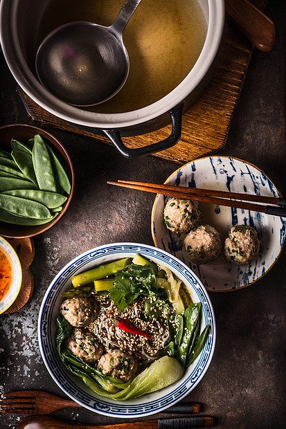 亚洲肉丸条汤碗与筷子上提供黑暗的乡村背景,顶部的视野亚洲美食的图片