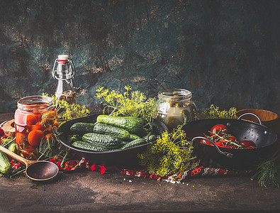 黑暗的墙壁背景下,用黄瓜西红柿腌制罐装保存乡村餐桌上的原料健康发酵食品的干净的饮食收获储存图片