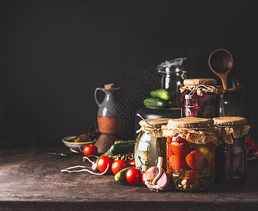 蔬菜水果罐头各种保存璃瓶黑暗的桌子上自制的收获储藏健康的食物图片