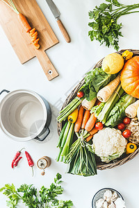 各种收获的机蔬菜,用于美味的季节烹饪白色厨房桌上的木托盘中食用,带砧板锅草药香料的风景现代健康的生图片