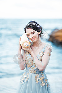 新娘穿着蓝色婚纱,海滩上个大贝壳图片
