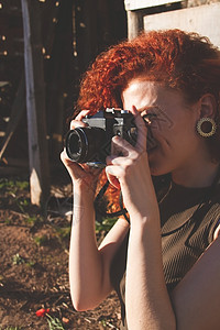 轻的红头发摄影师女人户外享受她的激情图片
