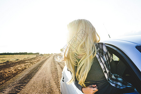 轻的女人次公路旅行中享受着旅程图片