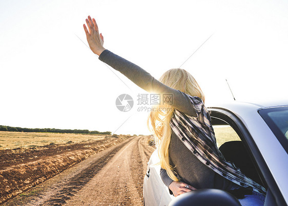 轻的女人次公路旅行中享受着旅程图片