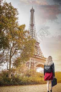 穿着红色裙子的女孩站埃菲尔铁塔的背景上巴黎图片