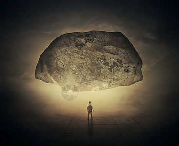 个男人,背上个袋子,站条雾蒙蒙的街道上,个巨大的挤压岩石下生活压力压力背景图片
