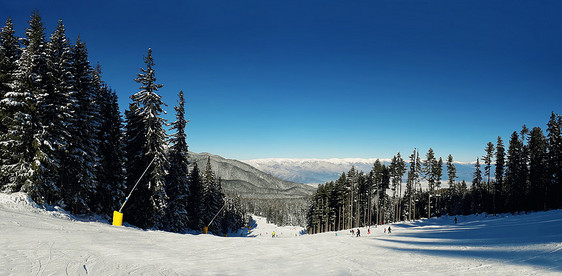 冬季雪山全景晴朗的天,风景滑雪道上蓝天皮林峰风景如画的冰川岩石斜坡图片