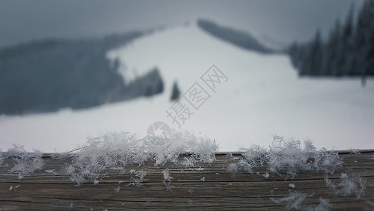 木桌上覆盖着柔软的雪花,背景美丽的山脉图片