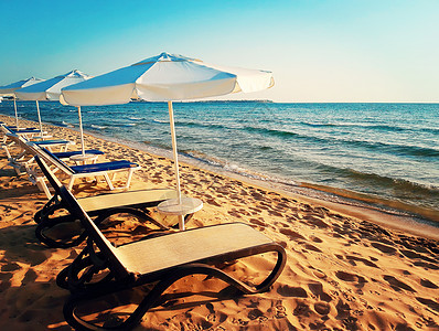美丽的沙滩,阳光明媚,海伞迎着早晨的日出保加利亚内塞巴尔的夏季背景图片