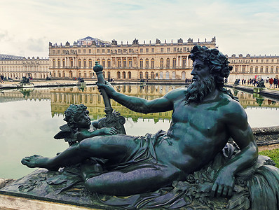 青铜雕塑凡尔赛宫花园靠近巴黎,法国与喷泉水的倒影图片