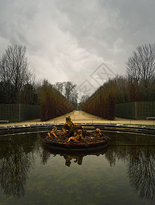 凡尔赛宫花园中的喷泉冬季,裸露的树木反射水中图片