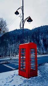 经典的红色英国电话盒,卡帕提安山锡那亚的雪地街道上图片