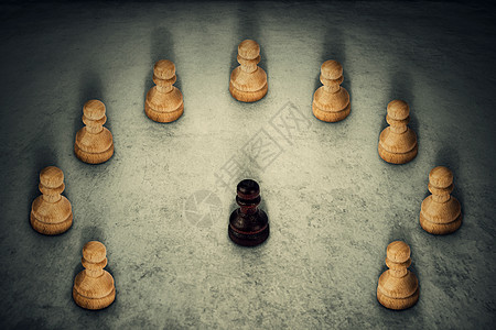 黑色棋子被白色棋子包围,把它们的力量连接商业集领导队工作的象征种族主义欺凌图片