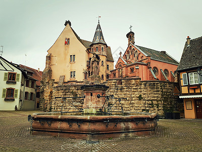城堡,教堂喷泉命名为莱昂埃吉斯海姆村的中心广场,阿尔萨斯,法国图片
