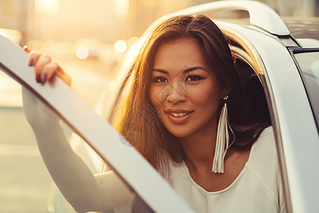 轻的亚洲妇女城市背景上打开车门肖像温暖的晚霞亚洲女人的肖像图片