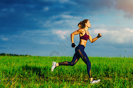 轻的苗条运动女人夏天的田野上跑步轻的苗条运动女人图片