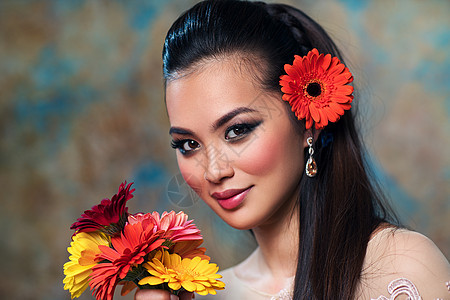 轻的亚洲女人带着鲜花,温柔的时尚肖像轻的亚洲女人图片