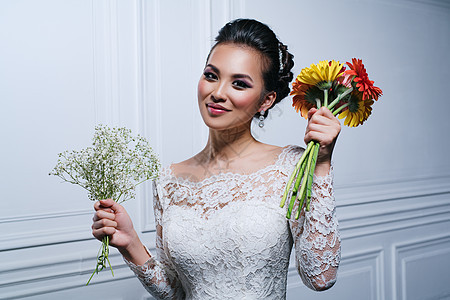 轻微笑的亚洲女人,穿着白色连衣裙,戴着鲜花,时尚肖像轻女时尚肖像图片