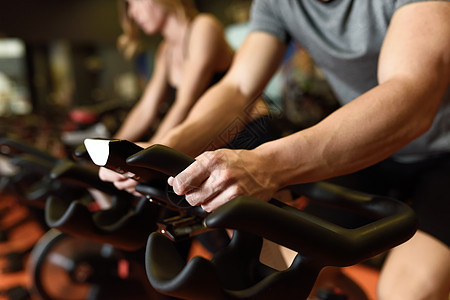 健身房骑自行车的男人的手的特写,锻炼腿部氧运动自行车夫妇课上穿着运动服图片