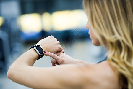 轻的女人健身房用智能手表高加索女健身图片