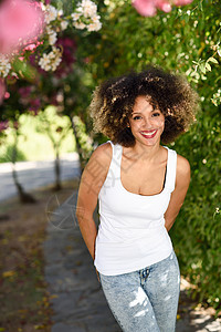 轻的黑人妇女,留着AFRO发型,城市公园微笑穿着休闲衣服的混合女孩图片