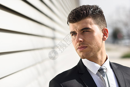 轻的商人现代办公楼附近穿着黑色西装领带蓝眼睛的男人图片