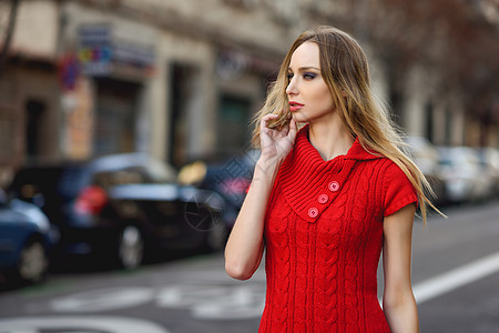 轻的金发女人看着街上的东西城市背景的漂亮女孩穿着红色的连衣裙直发的女图片