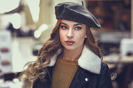 城市背景的金发俄罗斯女人漂亮的轻女孩穿着贝雷帽,黑色皮夹克迷你裙站街上漂亮的女,留着长长的波浪发型蓝色的眼睛图片